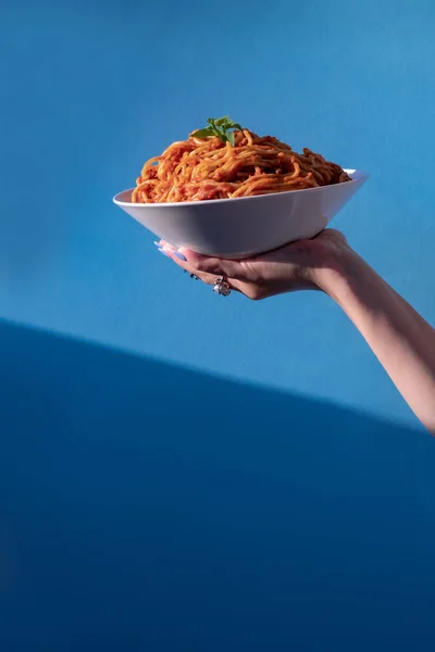 Női Kéz Kezében Egy Tányér Spagetti Tészta Paradicsommártással Fehér Tányéron Stock Fotó