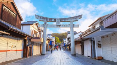 Fukuoka, Japonya - 30 Kasım 2022: Dazaifu Tenmangu Omotesando Alışveriş Sokağı 200 metre uzunluğunda, her iki tarafında mağazalar ve üç taş torii kapısı ile Dazaifu Tenmangu Tapınağı