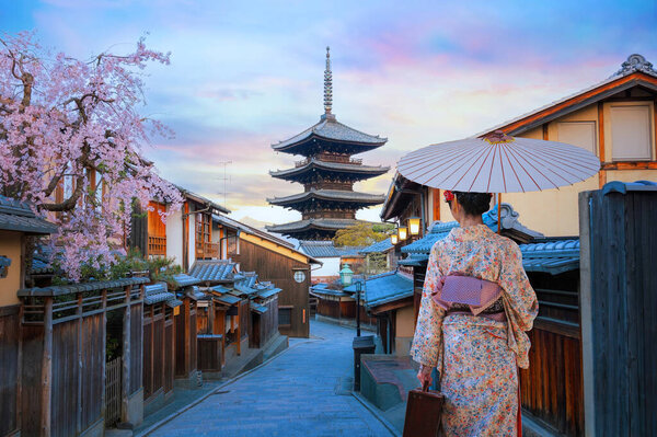 Young Japanese Geisha in traditional Kimono dress with Yasaka Pagoda at Hokanji temple in Kyoto, Japan