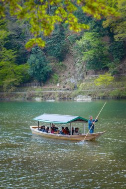 Kyoto, Japonya - 5 Nisan 2023: Tanımlanamayan insanlar Arashiyama ilçesinde Katsura nehrinde yelken açan bir tekneye biniyorlar