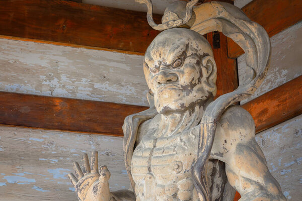 Nio, wrathful and muscular guardians of the Buddha stand guard at the  of Ninnaji temple's gate in Kyoto, Japan