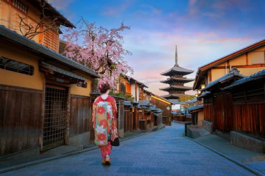 Yasaka Pagoda 'nın Kyoto' daki şehir manzarası. Geleneksel Kimono elbiseli genç bir Japon kadınla bahar aylarında kiraz çiçekleri açarken.