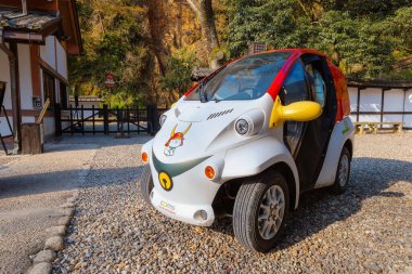 Shiga, Japonya - 3 Nisan 2023: Hikonyan maskot kedisi ile süslenmiş bir Toyota EV arabası, Hikone Kalesi memurları tarafından kullanılıyor, kalenin ve bilet kapısının tepesine tırmanıyor ve iniyor.