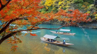 Kyoto, Japonya - 18 Kasım 2024: Arashiyama bölgesindeki Katsura nehrindeki Hozu Nehri Tekne Gezileri 'nde kimliği belirsiz kişiler
