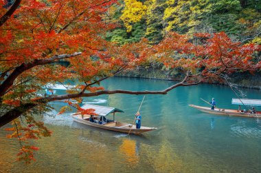 İnsanlar Arashiyama bölgesindeki Katsura nehrinde Hozu Nehri Tekne Gezileri 'ne katılıyor.