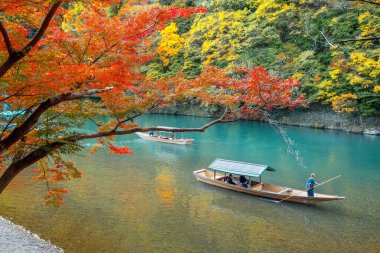 İnsanlar Arashiyama bölgesindeki Katsura nehrinde Hozu Nehri Tekne Gezileri 'ne katılıyor.