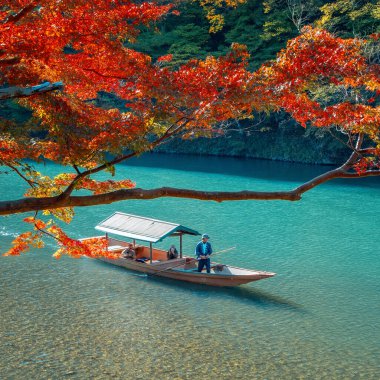İnsanlar Arashiyama bölgesindeki Katsura nehrinde Hozu Nehri Tekne Gezileri 'ne katılıyor.