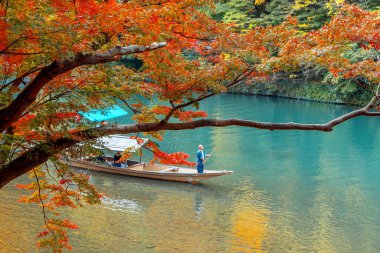 İnsanlar Arashiyama bölgesindeki Katsura nehrinde Hozu Nehri Tekne Gezileri 'ne katılıyor.