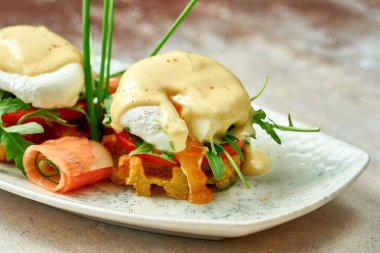 Hollandaise soslu haşlanmış yumurta ve tabakta somon balığı. Seçici odak, yakın plan