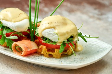 Hollandaise soslu haşlanmış yumurta ve tabakta somon balığı. Seçici odak, yakın plan