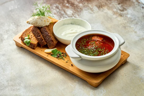 stock image Ukrainian borscht with lard and bread, sour cream in a plate. Close-up, selective focus