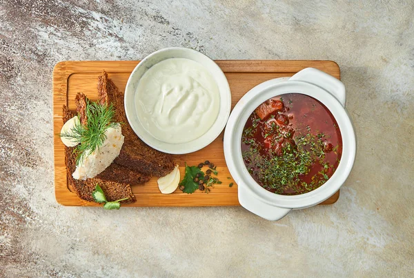 stock image Ukrainian borscht with lard and bread, sour cream in a plate. Close-up, selective focus