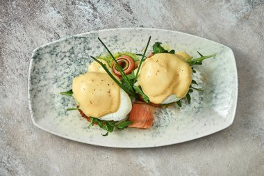 Hollandaise soslu haşlanmış yumurta ve tabakta somon balığı. Seçici odak, yakın plan