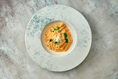 Domates soslu makarna ve tabakta parmesan peyniri. Yakın çekim, seçici odaklanma.
