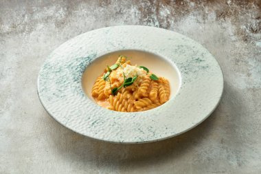 Domates soslu makarna ve tabakta parmesan peyniri. Yakın çekim, seçici odaklanma.