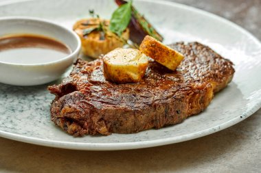 Baharatlı tereyağı ve soslu klasik biftek. Yakın çekim, seçici odaklanma