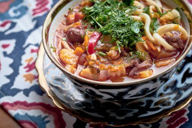 Laghman soup with meat, vegetables and pulled noodles served in plate. 