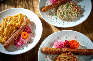 Üç tane Bavyera sosisi ve ahşap arka planda tabaklar. sucuk.