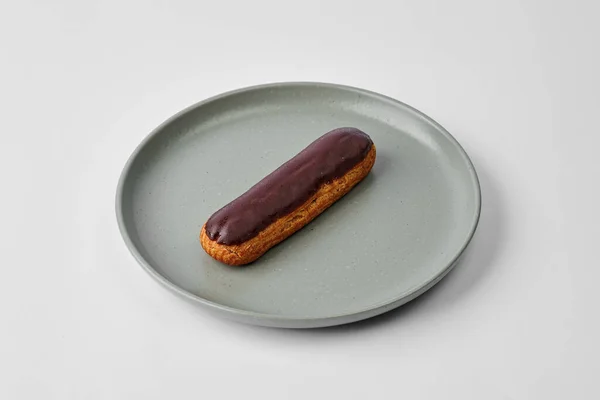 Éclair Français Avec Glaçure Chocolat Dans Une Assiette Sur Fond — Photo