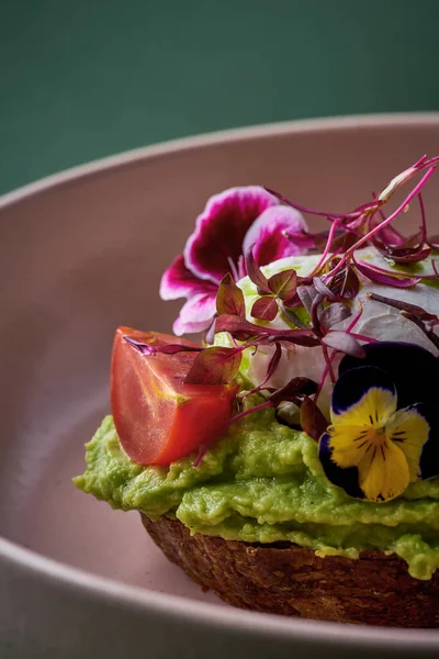 stock image Avocado toast with eggs benedict and flowers in a plate