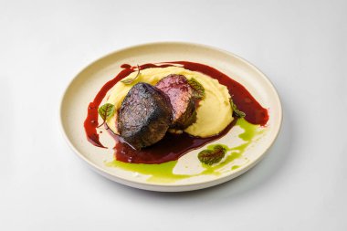 Böğürtlen soslu fileto ve tabakta patates püresi.