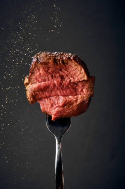 Mignon filetosu bir çatalın üzerine tuz ve baharat serpiştirilir. Orta pişmiş.