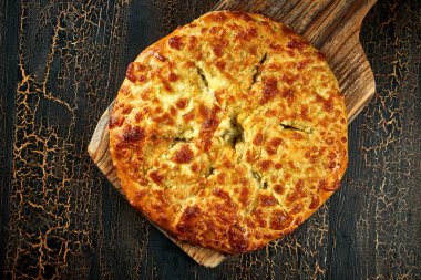 Klasik bir Gürcistan turtası - Kil tabakta tuzlu peynirli Megrelian khachapuri