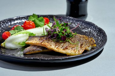 Tabakta sebzeli kızarmış deniz kabuğu filetosu.