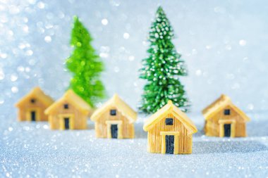 Oyuncak Noel ağaçlarının etrafına yerleştirilmiş minyatür ahşap evler..