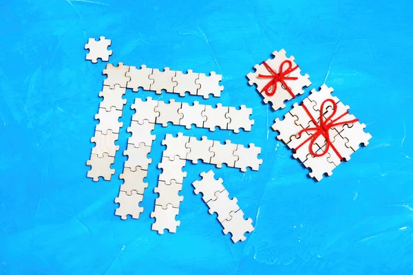 用蓝色拼图拼图拼凑而成的圣诞树和包装好的礼品盒 创意圣诞背景概念 — 图库照片