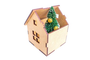 Beyaz arka planda izole edilmiş bir oyuncak ahşap evin içine yerleştirilmiş Noel ağacı heykelciği. Doğru yeni yıl ağacını seçiyorum.