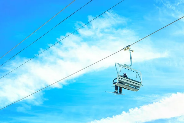 Skier Ιππασία Μια Καρέκλα Ανελκυστήρα Ενάντια Ένα Ζωντανό Μπλε Ουρανό — Φωτογραφία Αρχείου