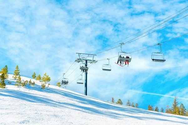 리프트 눈덮인 산비탈에 있으며 놀라울 정도로 하늘을 배경으로 스키를 타거나 — 스톡 사진