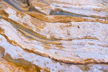 Katmanlı kayalardan oluşan soyut arkaplan jeolojik oluşumların doğal güzelliğini ve karmaşıklığını gözler önüne seriyor..
