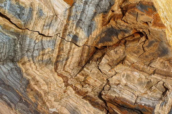 抽象的な地質学的背景は 複雑な層と土の色を持つ自然の岩の形成の見事なディスプレイを特徴とし ユニークで魅惑的な視覚的なテクスチャを作成します — ストック写真