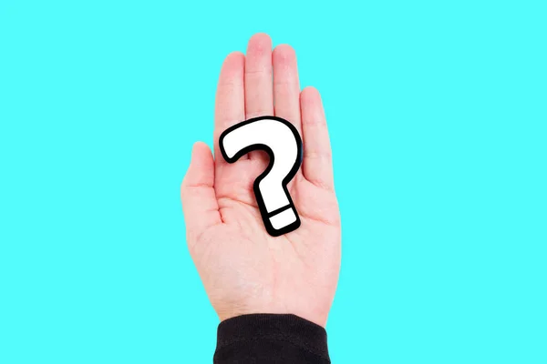 Crop view of a female hand with a large black and white question mark symbol, isolated on a plain blue background. Inquiry, curiosity, confusion or skepticism concept.