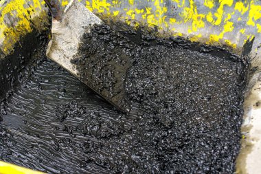 Bir el arabasından kürek kepçeleme terrazzo kaldırım karışımı. Şöhret Yolu onarım altında.