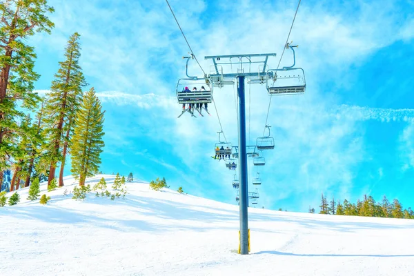 晴れた冬の日には青空を背景に下から見えるようにリフトに乗って山に登る — ストック写真
