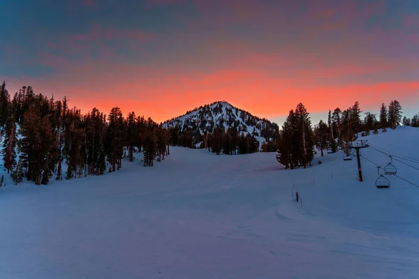 マンモススキー場の雄大な夕日の景色と雪に覆われた斜面 オレンジの赤の色合いは暖かさと活気を追加します — ストック写真
