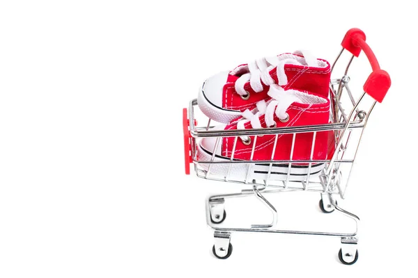Egy Pár Apró Piros Magas Vászoncipőt Helyeztek Egy Kis Bevásárlókocsiban — Stock Fotó