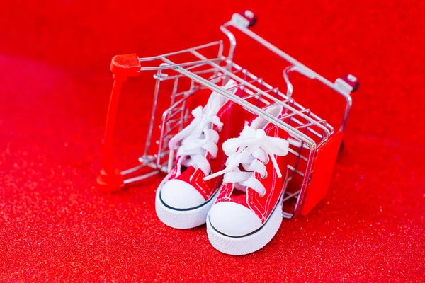 Egy Pár Mini Piros Vászon Cipő Egy Felborult Miniatűr Tolókocsiba — Stock Fotó