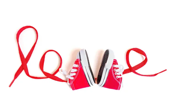Слово Любовь Прописано Красным Кружевом Двумя Маленькими Красными Ботинками Холста — стоковое фото
