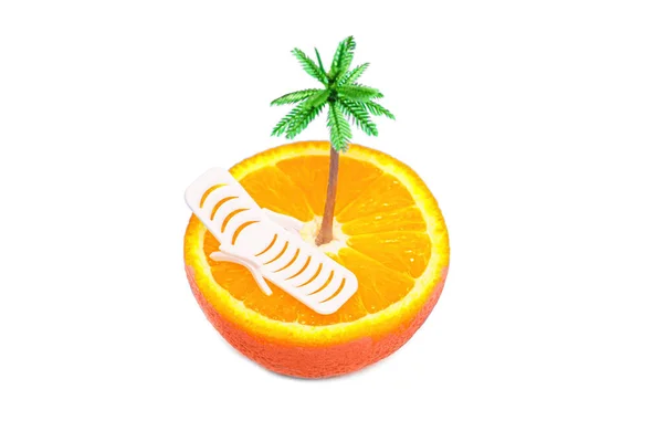 橙色水果切成两半 在白色背景上与玩具棕榈树和迷你躺椅顶部隔离 并有复制空间 暑假设计和旅行促销概念 — 图库照片