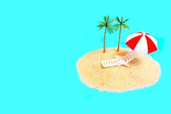 在蓝色背景的小沙堆上放置了带有休闲焦炭 遮阳伞和棕榈树雕像的迷你玩具构图 热带岛屿度假创意概念 — 图库照片