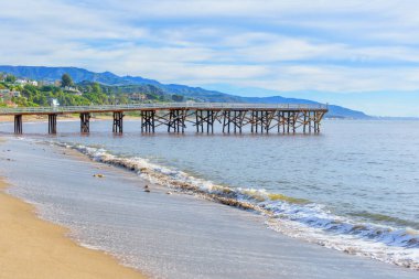 Okyanusa doğru uzanan ahşap iskele ile kıyı gündoğumu manzarası Malibu, Kaliforniya 'da kurulu görkemli dağlar ve büyüleyici evlere karşı..