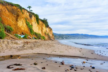 Malibu, California 'da kayalık bir uçurumu, kumlu kıyısı ve okyanus manzarası olan güzel bir kıyı manzarası..