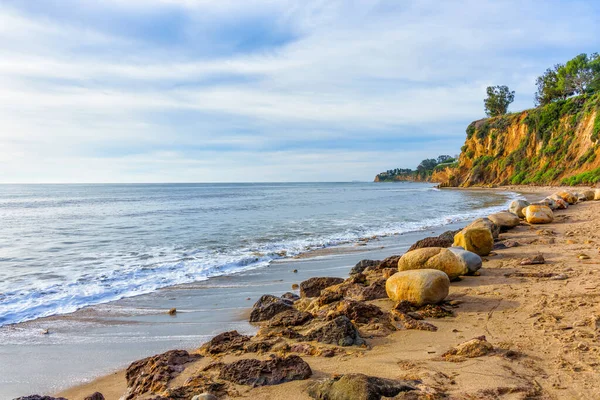 Okyanus dalgaları, kayalar ve temiz ufuklarla sakin Malibu sahnesi.