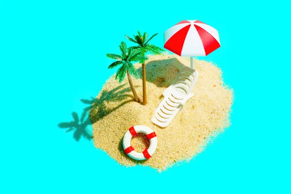 在清澈的蓝绿色背景下 用沙子 微型玩具棕榈树和一个白色的休闲椅 在迷人的太阳伞下 构成了一个遥远的沙滩岛屿 — 图库照片