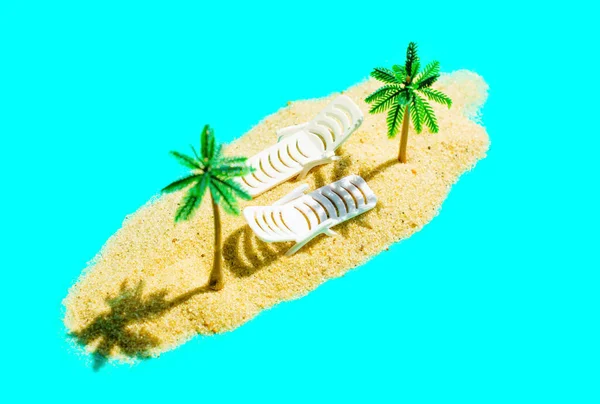 由玩具棕榈树 两个白色躺椅和绿松石蓝色背景上的沙堆组成的迷你海滩逃生组合 — 图库照片