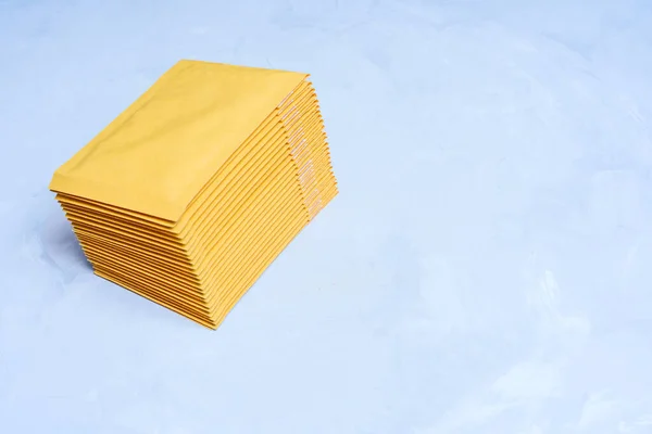 Wysoki Kąt Widzenia Stosu Żółtych Listonoszy Bąbelkowych Umieszczonych Szarym Betonowym — Zdjęcie stockowe